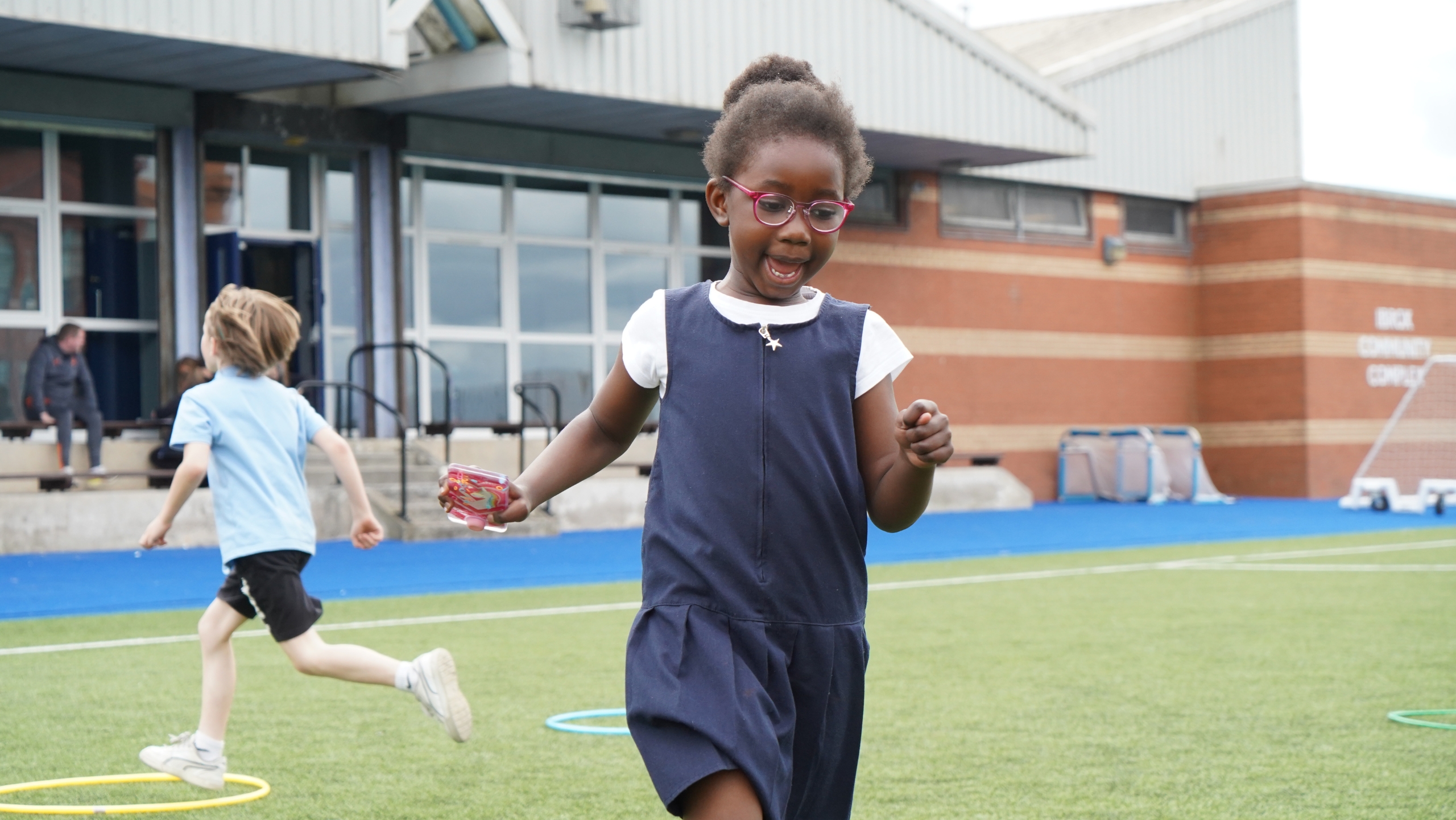 A school pupil running around a football pitch