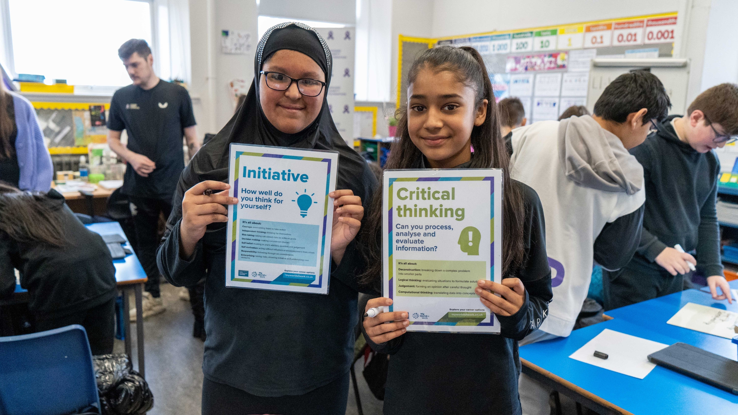 Two school pupils holding up their Diversity Wins booklets