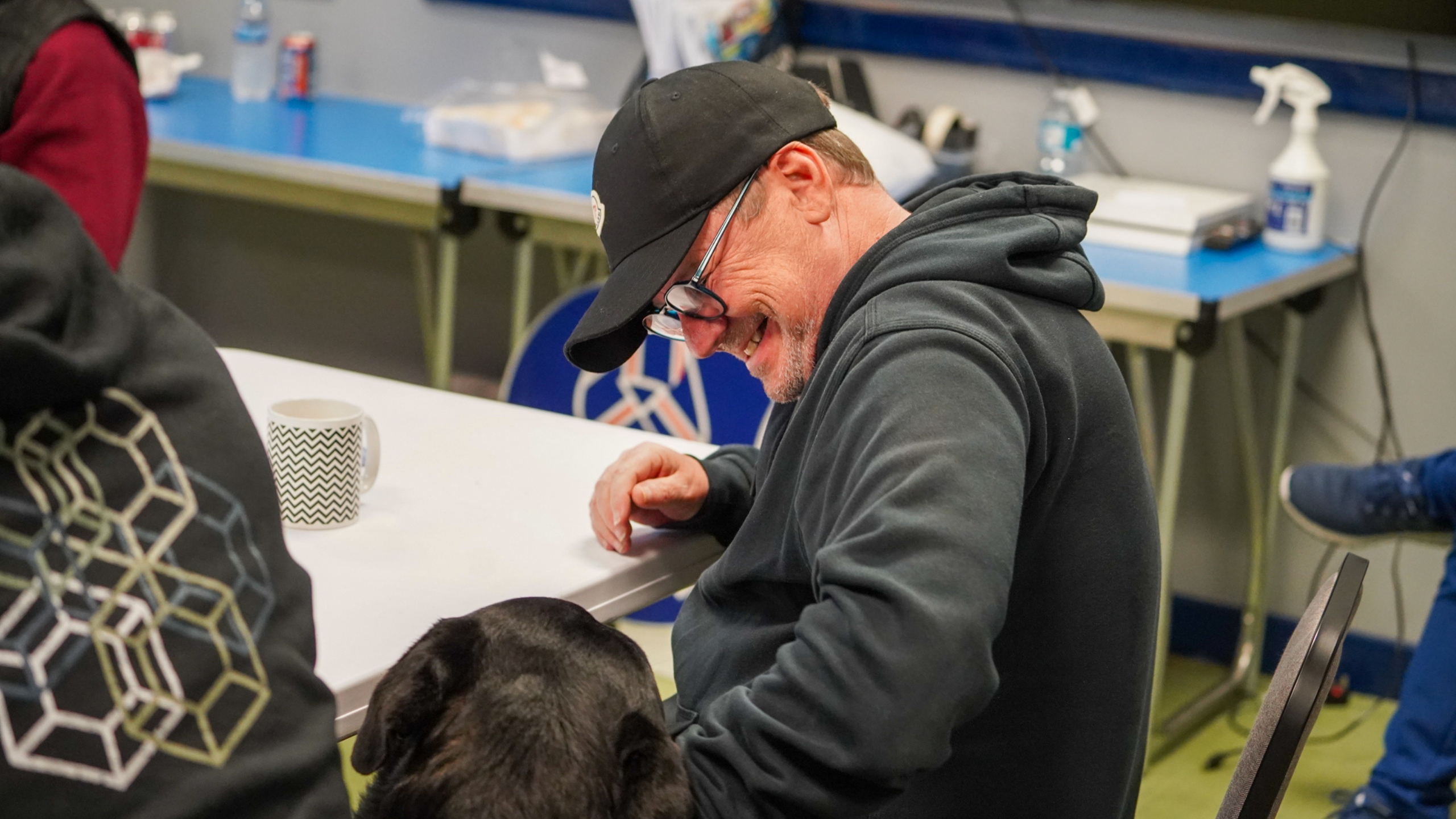 A man smiling while looking at a dog