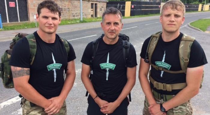 Three men standing after completing a long hike