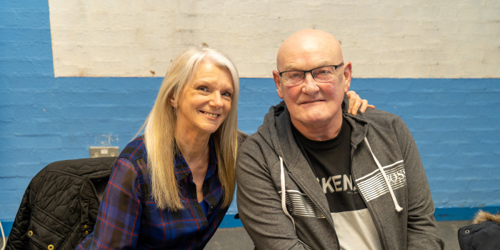 Two people sitting in a old brick room