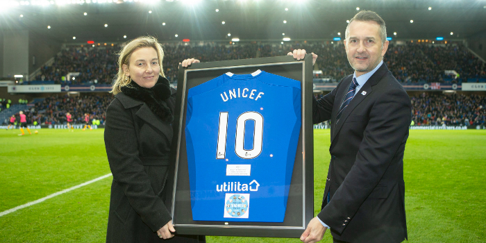 Connal Cochrane presents UNICEF with a 10th anniversary jersey on the pitch at Ibrox