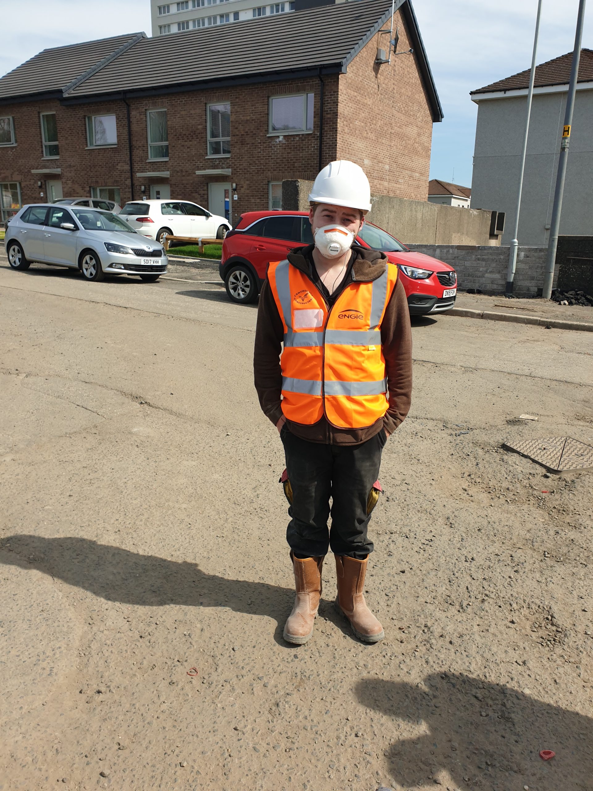 A builder standing in their work clothes