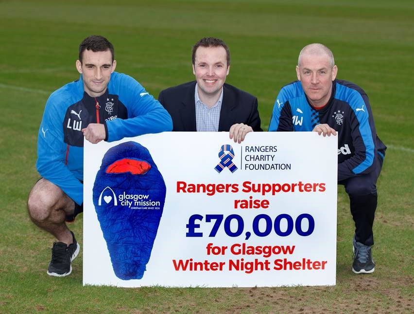 Walter Smith, Lee Wallace and 1 other holding prop cheque showing amount of donation for winter shelter