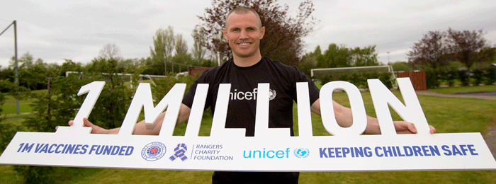 Kenny Miller holding Unicef prop -1million vaccines funded