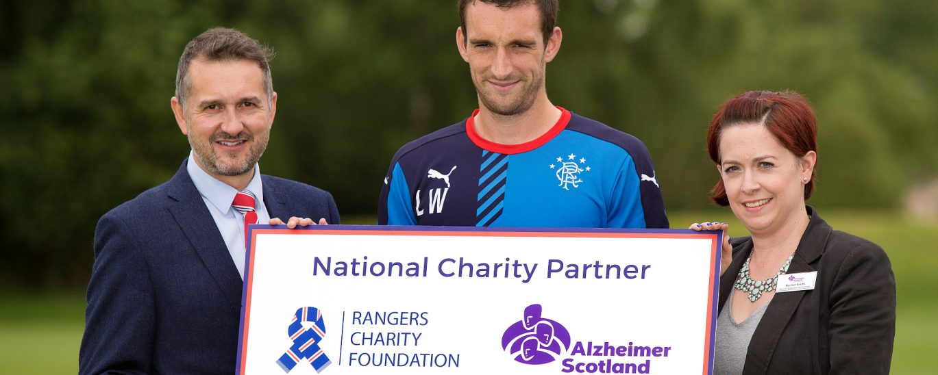 Connal Cochrane , Lee Wallace and 1 lady holding a charity partner prop