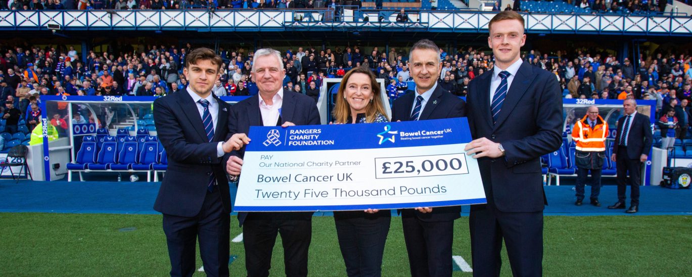 A group of people being presented with a giant cheque for £25,000