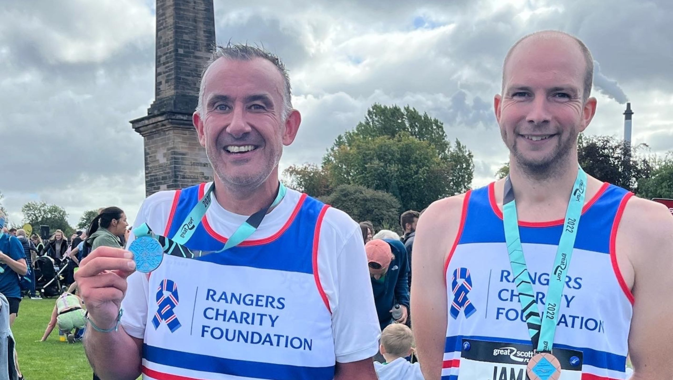 Two men in a Rangers running vest with medals