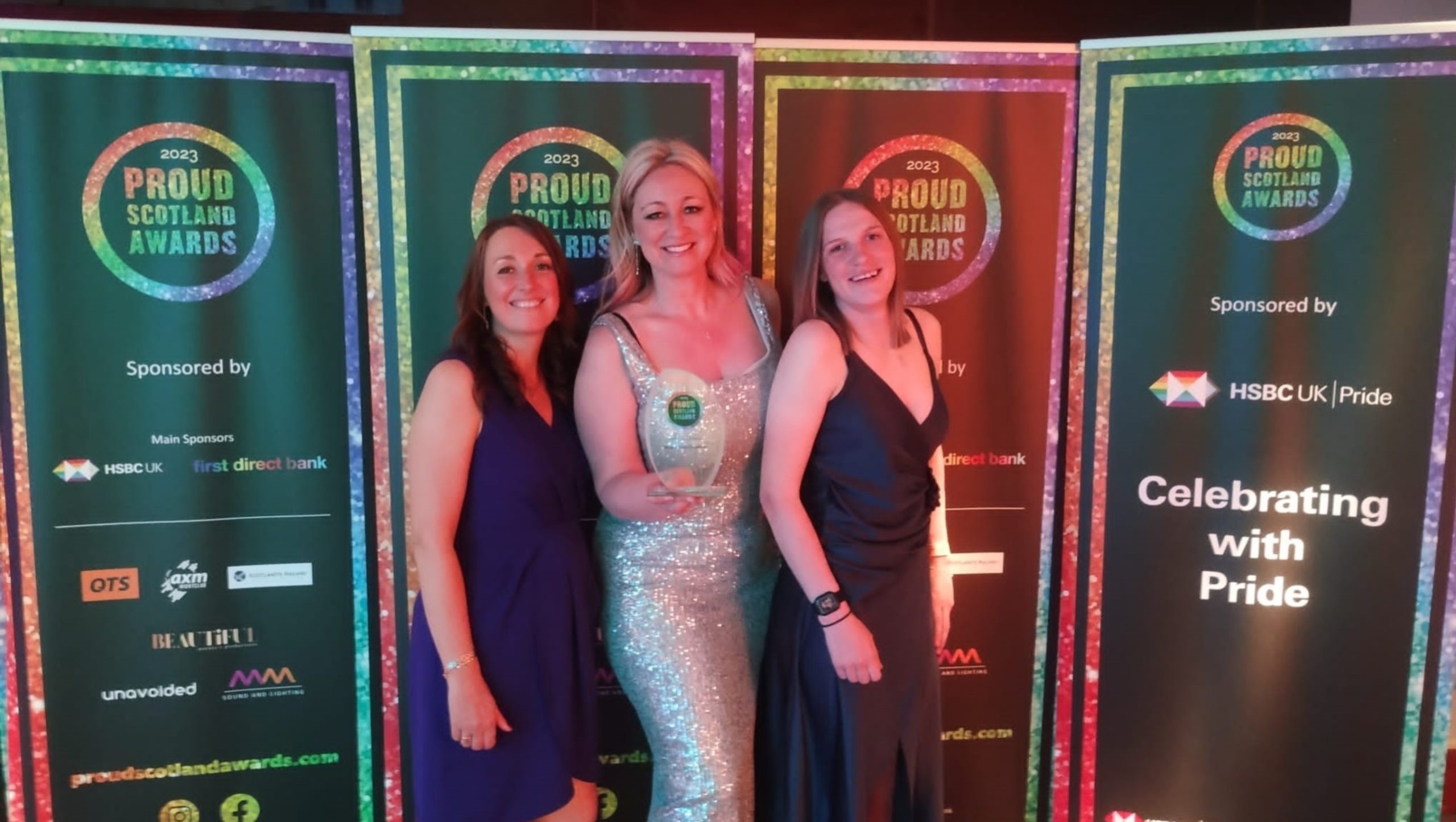 3 female members of staff holding award at Proud Scotland