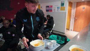 academy player cleaning up dishes