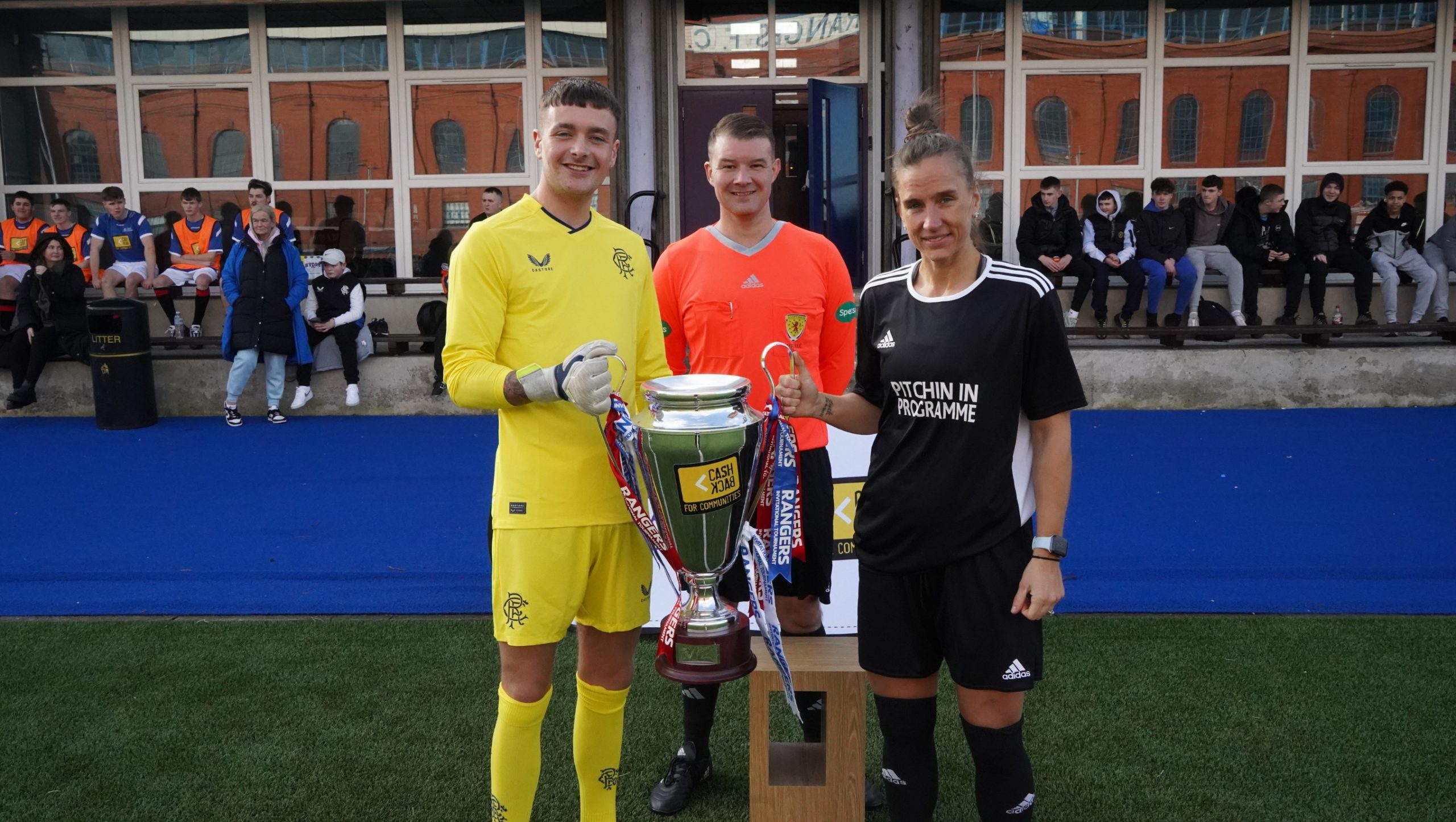 Three people standing holding a trophy
