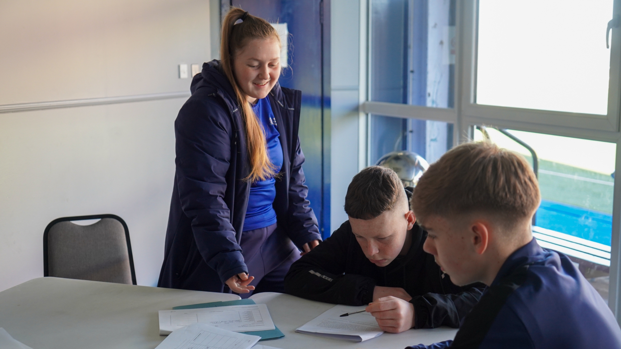 A Rangers Charity Foundation staff member helping participants with their work.
