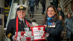 two serving personnel with poppies and buckets