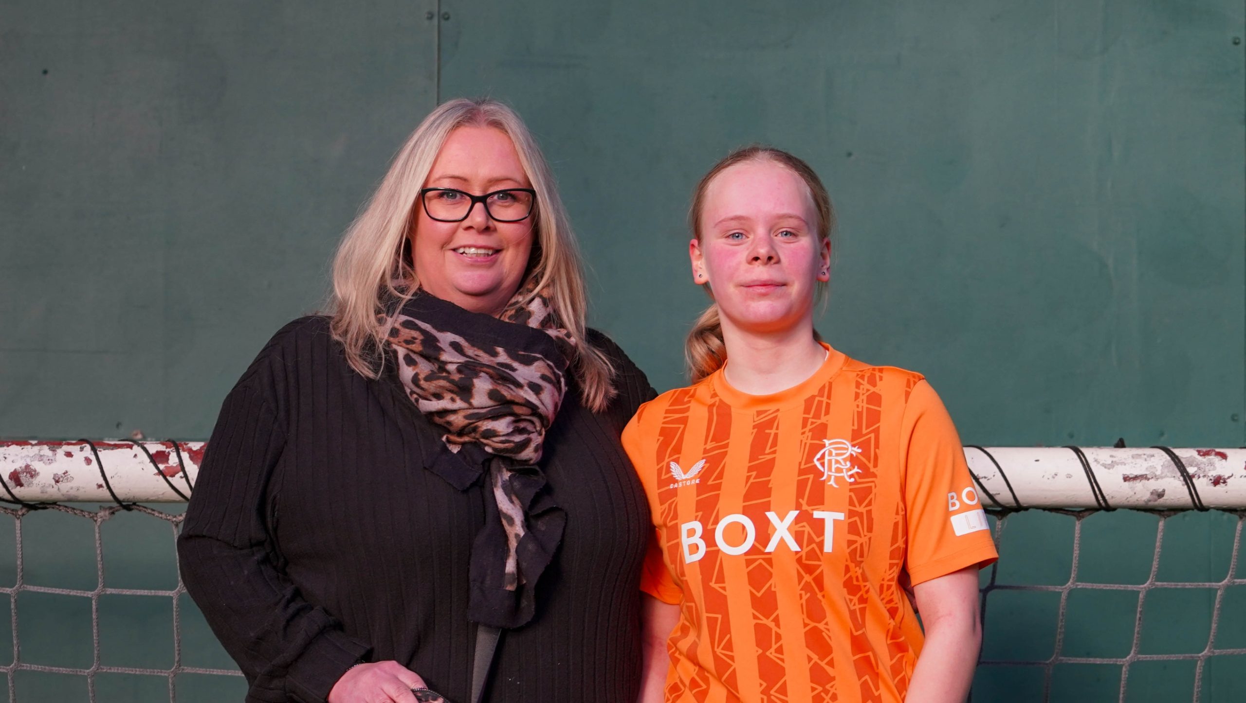 A young girl and her mother posing for a photograph together