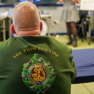 A man veteran sitting in a group session listening to the group leader.