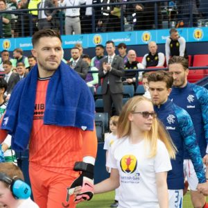 A visually impaired football participant walking out at Hampden with Rangers FC player Jack Butland