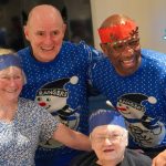 Marvin Andrews and Gordon Durie taking a photo with senior citizens.