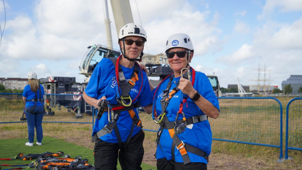 2 people with helmets and harnesses