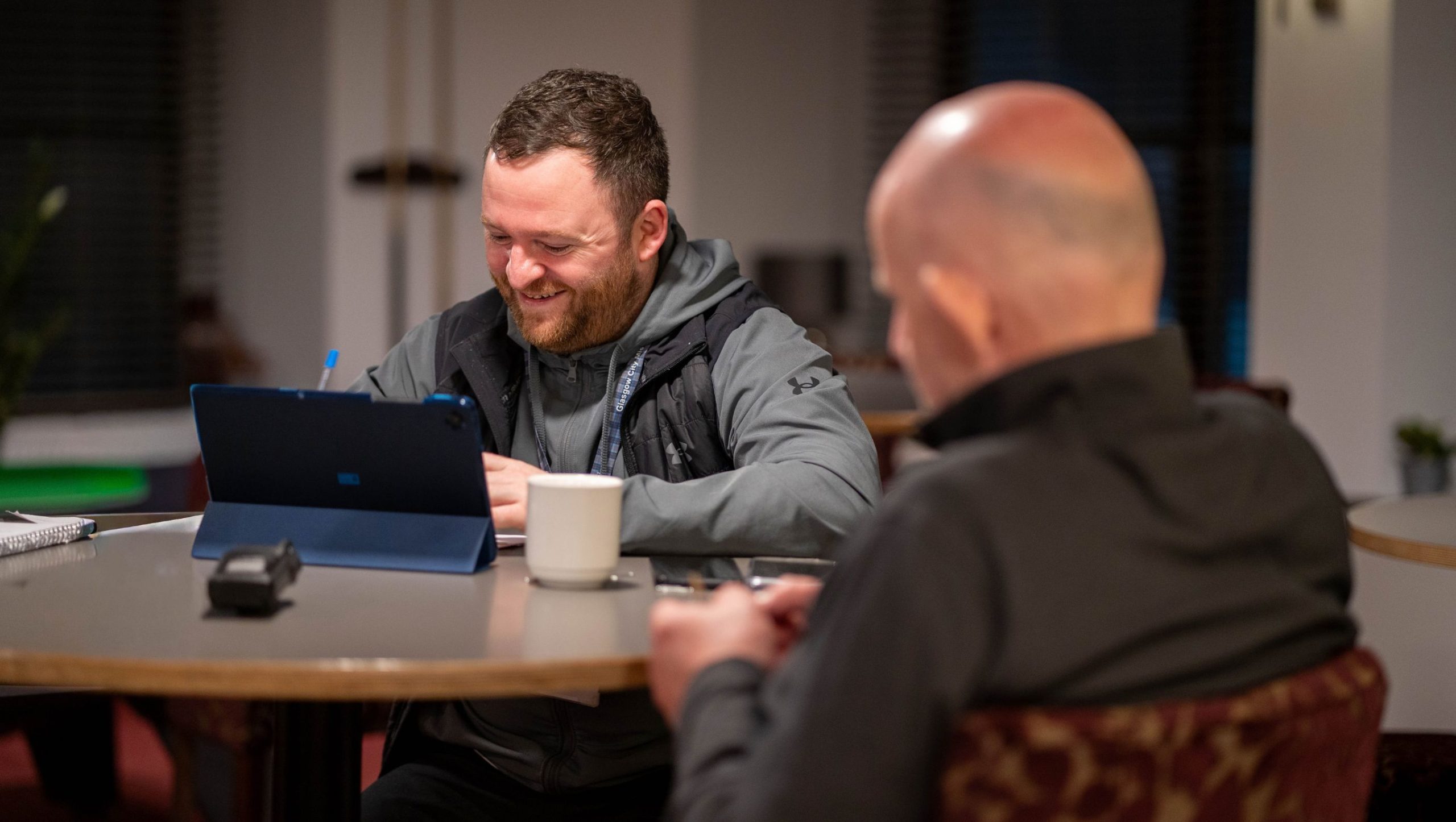 two men talking with a laptop